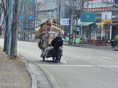 Hình ảnh một cụ ông đang kéo xe giấy cao vút, chắc hôm nay cụ lượm được nhiều hơn mọi khi... nên có vẻ bước c:hân cũng n:ặng hơn...